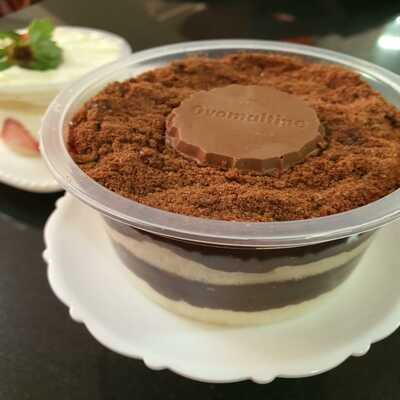 Uma imagem de um lindo e delicioso bolo de pote com cobertura de flocos de chocolate